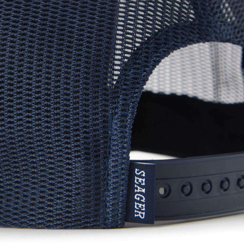 Close-up of a navy blue mesh cap with a white interior and black strap, featuring the brand 'Seager'.