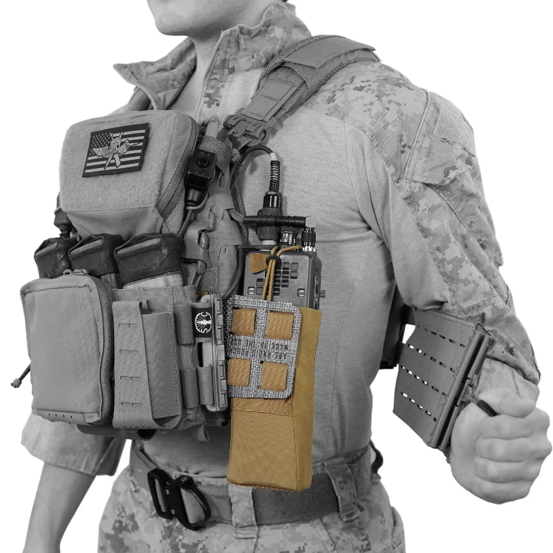 Person wearing a tactical vest with various pouches and equipment on a white background