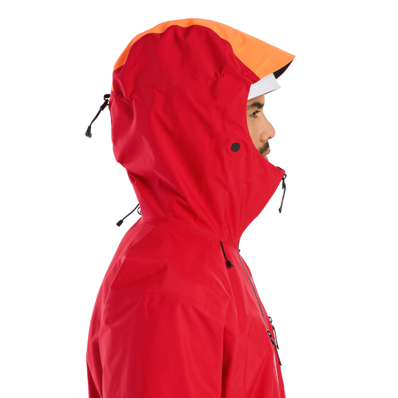 Front view of the Arc'teryx Alpine Guide Jacket in Dynasty II red with the hood up showing the professional ski guide StormHood design and GORE TEX PRO protection featured in the Arc'teryx on sale collection.