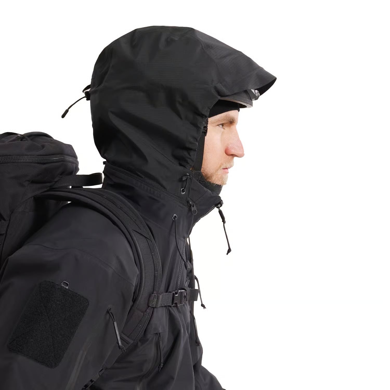 Side view of Arc'teryx PRO Alpha Jacket GEN 2.3 worn with hood deployed showing GORE TEX waterproof coverage and tactical shell profile