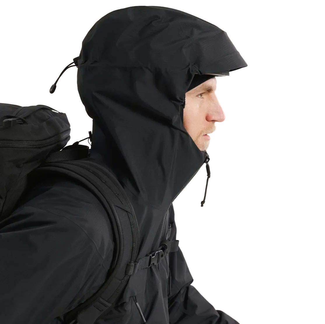 Close up of the Arc'teryx PRO Alpha LT Jacket Gen 2.2 in Black with the hood up, highlighting the fixed hood design, streamlined profile, and lightweight GORE TEX 3 layer construction. Part of the Arc'teryx PRO line, evolved from the LEAF program, and built for wet weather tactical operations.