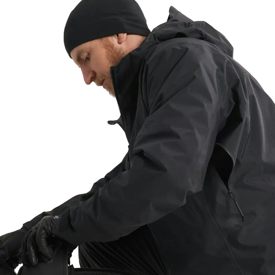 Close up detail of the Arc'teryx PRO Alpha LT Jacket Gen 2.2 in Black being worn with the side vent unzipped, showing the No Slip Zip ventilation system and lightweight GORE TEX 3 layer construction. Highlights the PRO-series tactical design, evolved from the LEAF line, built for heat management and mobility during high output operations.
