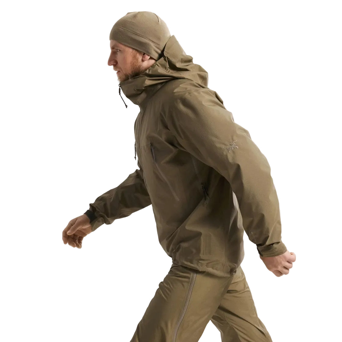 Full body side view of the Arc'teryx PRO Alpha LT Jacket Gen 2.2 in Crocodile showing the Arc'teryx logo on the upper arm along with the streamlined military fit and lightweight GORE TEX 3 layer construction. This PRO-series shell, evolved from the former Arc'teryx LEAF line, is designed for high mobility tactical movement and wet weather field operations.