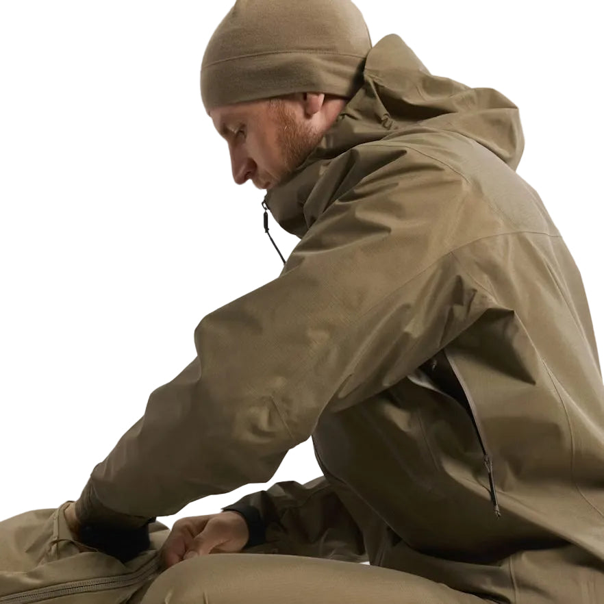 Close up view of the Arc'teryx PRO Alpha LT Jacket Gen 2.2 in Crocodile being worn with the side vent unzipped, showing the No Slip Zip ventilation system designed to release heat during high output movement. Highlights the lightweight GORE TEX 3 layer construction and PRO-series tactical design evolved from the former Arc'teryx LEAF line.