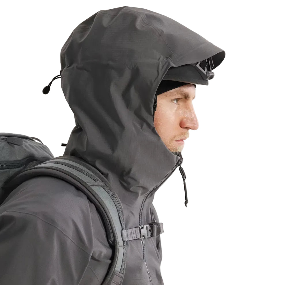 Hood-up view of the Arc'teryx PRO Alpha LT Jacket Gen 2.2 in Wolf Grey, showing the fixed hood design, streamlined PRO-series fit, and lightweight GORE TEX 3 layer construction. This tactical shell, evolved from the Arc'teryx LEAF program, provides full weather protection and mobility in wet field conditions.