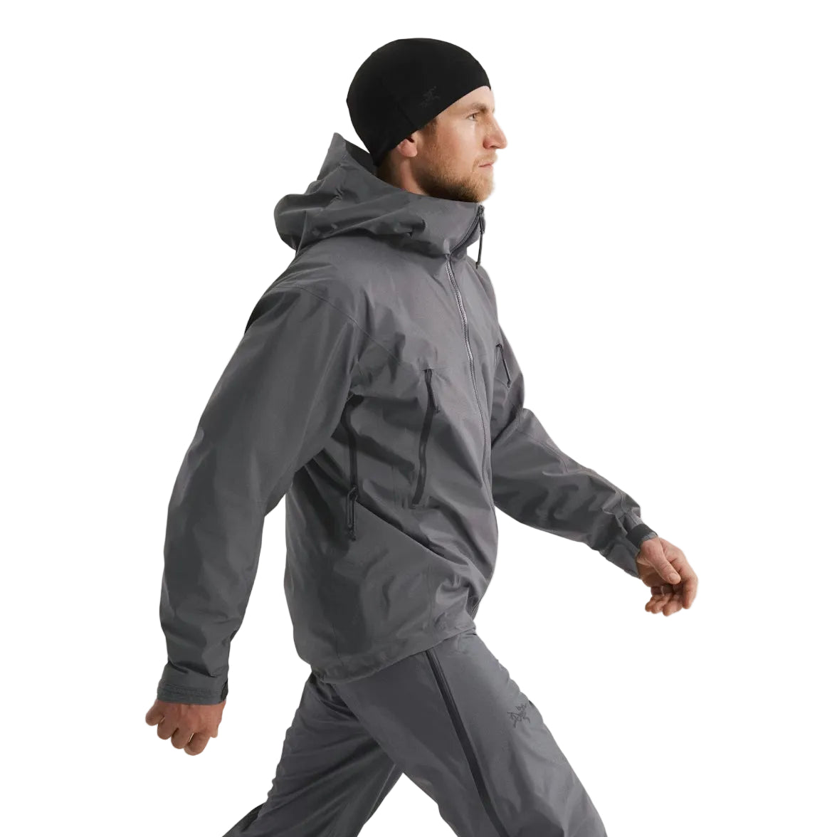 Side view of the Arc'teryx PRO Alpha LT Jacket Gen 2.2 in Wolf Grey worn with the hood down, highlighting the jacket length, streamlined military fit, and centerline zipper placement. Shows the PRO-series GORE TEX 3 layer construction, evolved from the Arc'teryx LEAF program, engineered for mobility and wet weather tactical performance.