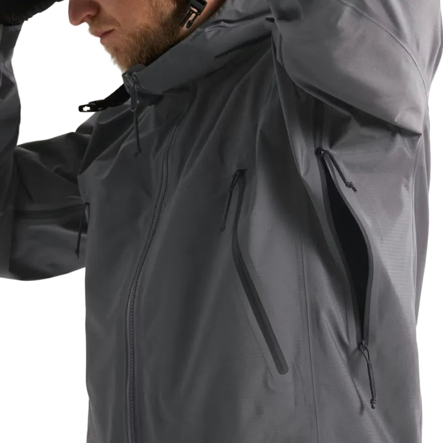 Detail view of the Arc'teryx PRO Alpha LT Jacket Gen 2.2 in Wolf Grey being worn with the side vent open, showing the No Slip Zip ventilation system, TPU zipper pulls, and seam construction. Highlights the PRO-series tactical design, evolved from the Arc'teryx LEAF program, engineered for heat management, mobility, and wet weather field performance.