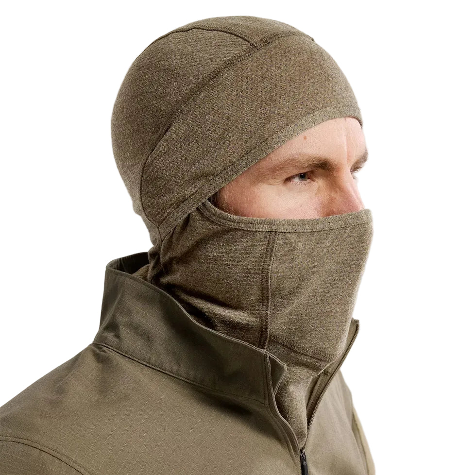 Three quarter view of the Arc'teryx PRO Assault Balaclava FR Gen 2 in Crocodile worn with the mouth and nose covered, highlighting the flame resistant Defender M mesh knit, enhanced breathability over the nose and mouth area, and ergonomic low-profile fit designed for helmet, comms, and eyewear integration. Built for direct action missions requiring FR protection and high airflow.