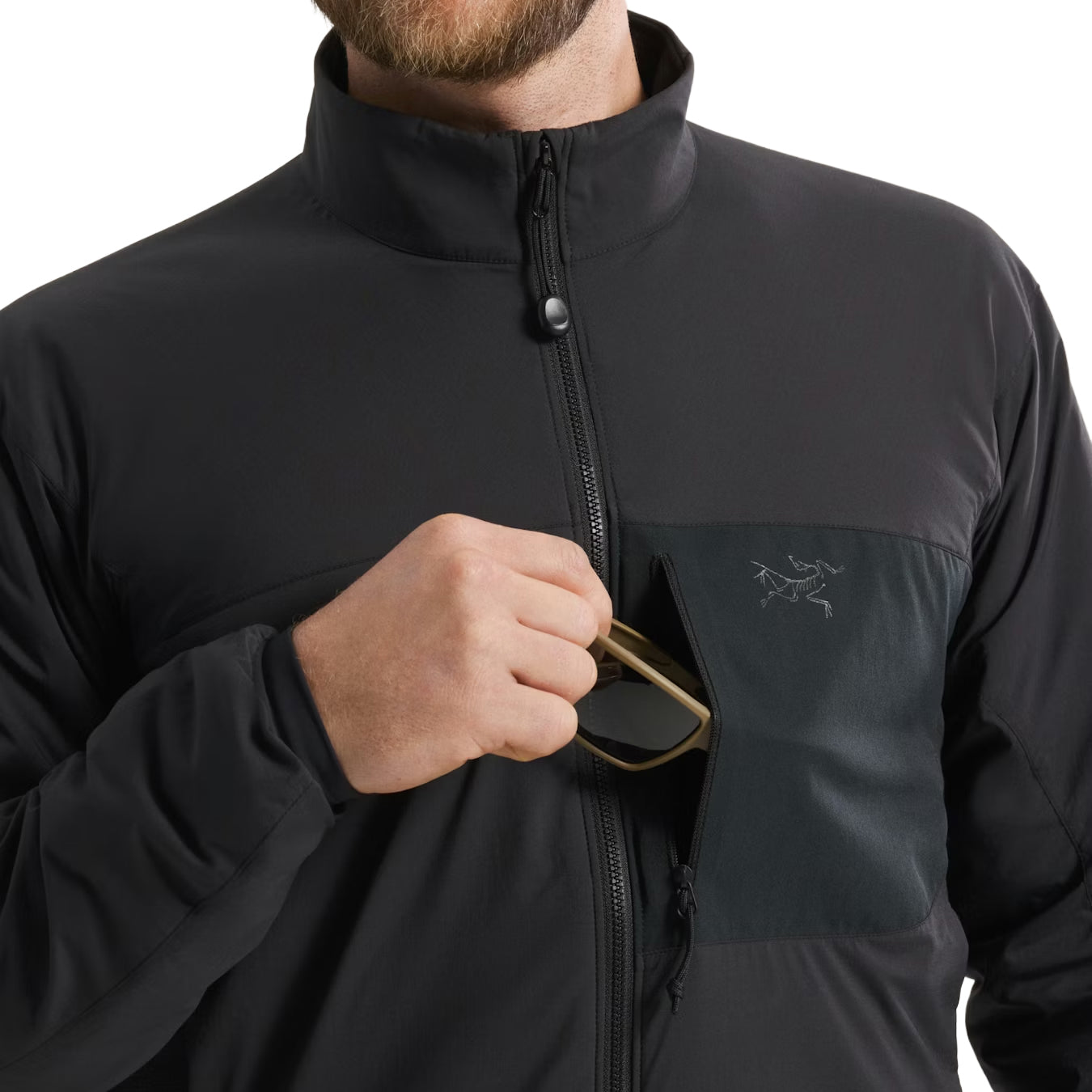 Close up of Arc'teryx PRO Atom LT Gen 2.1 Black hand pocket in use, insulated tactical jacket with zippered storage and media port routing designed for comms management and cold weather field performance