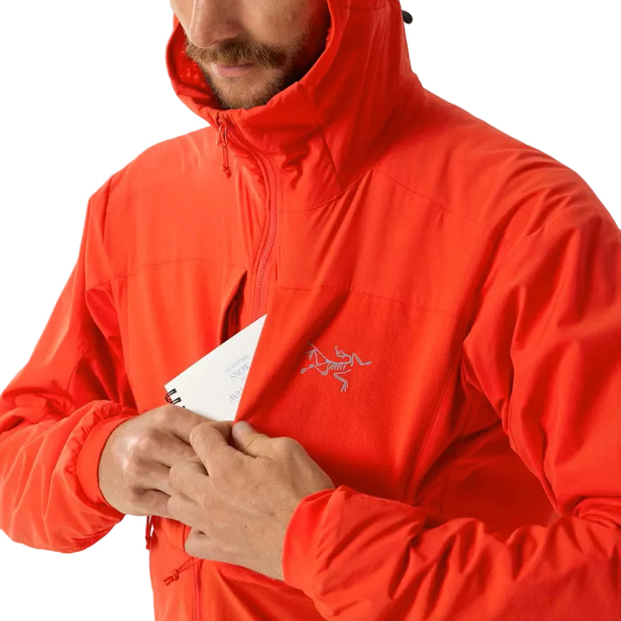 Image showing the Arc'teryx PRO Practitioner AR Hoody in Dynasty with a hand accessing the front zip pocket, highlighting the dual chest storage design, streamlined access, and mission ready pocket placement for tactical operators and outdoor professionals in the United States.