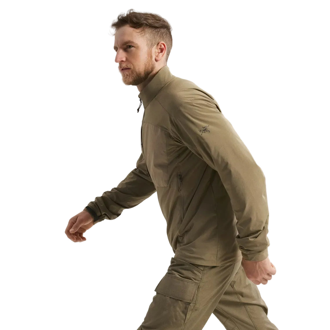 Side view of the Arc'teryx PRO Practitioner AR Jacket in Crocodile being worn, showing the Arc’teryx arm logo, articulated patterning, and streamlined Fortius Air 50 shell. Highlights the PRO-series mid layer’s mobility, breathable Octa Loft insulation, and mission-ready design built for tactical environments, cold-weather layering, and high-output field use.