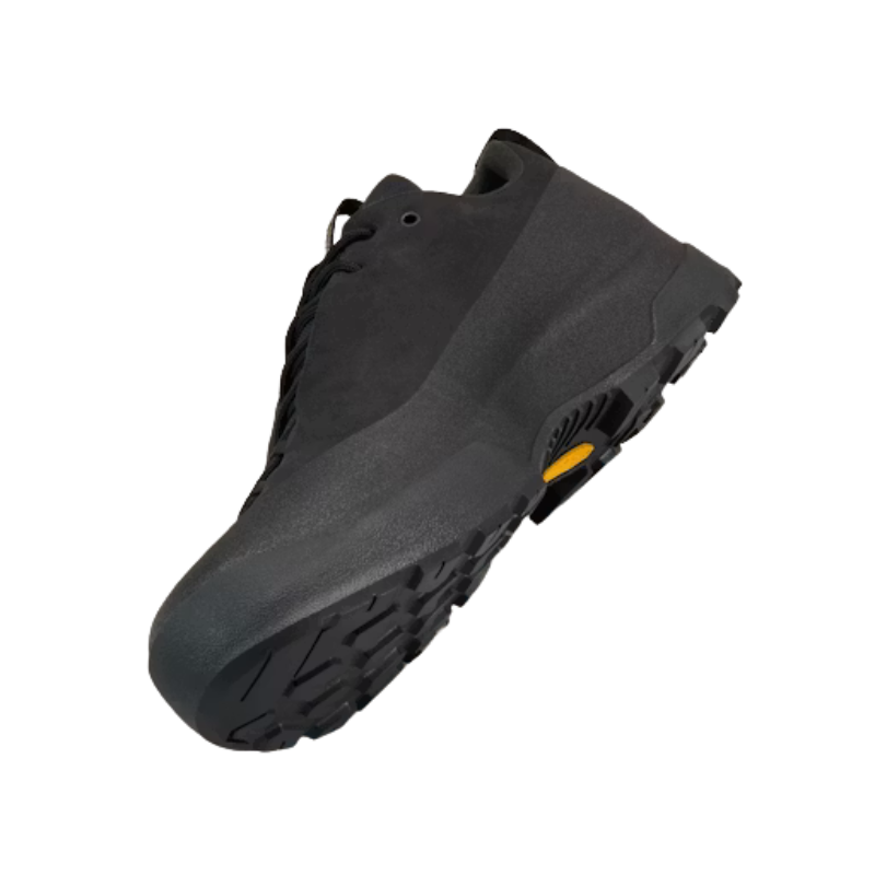 A black outdoor Arc'teryx shoe with a textured rubber sole and a small yellow Vibram accent on the bottom, shown against a plain white background.