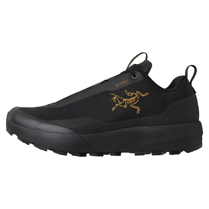 A black Arc'teryx slip-on shoe with a gold dead bird logo on the side, set against a plain white background.