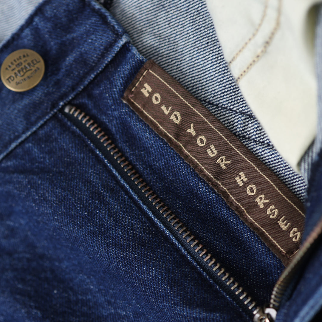Close-up of a denim jacket with a brand label on a blurred background