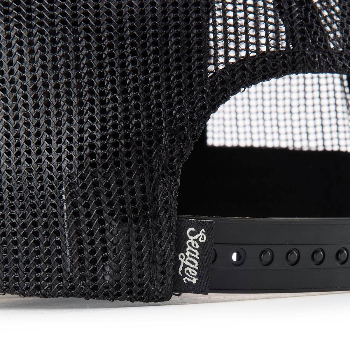 Close-up of a black mesh cap with a Seager brand logo on a white background