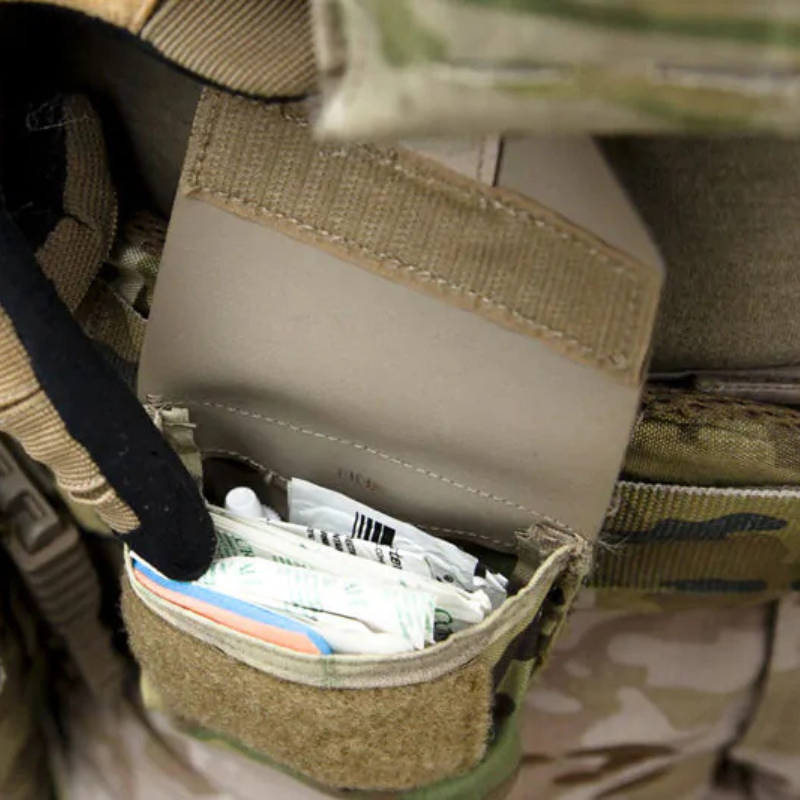 Blue Force Gear Boo Boo Kit Pouch opened to reveal organized medical supplies and small gear for rapid access in the field.