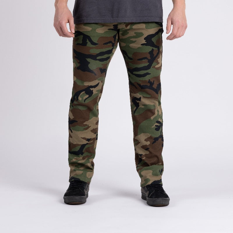 Front view of Carlos Ray Chino Tactical EDC Pants in Woodland camo showing sleek low-profile chino style with soft stretch cotton twill, gusseted crotch for unrestricted movement, and concealed tactical features like hidden handcuff key pocket, reinforced front pocket edges, and mag-ready back yoke pockets for discreet everyday carry