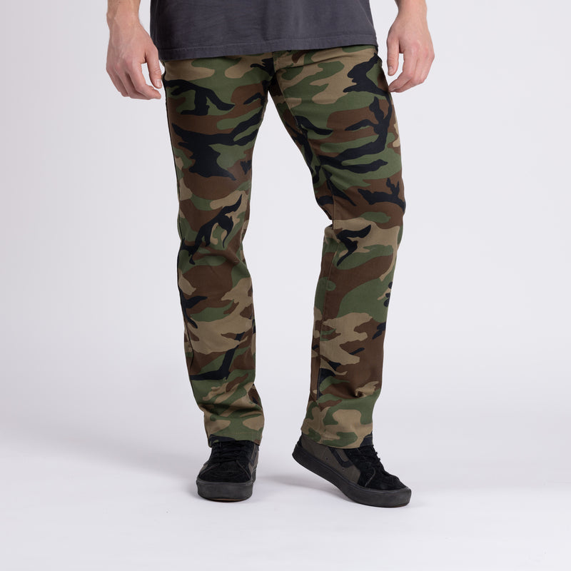 Front view of Carlos Ray Chino Tactical EDC Pants in Woodland camo demonstrating stretch and full range of motion, showcasing soft 4-way stretch cotton twill, gusseted crotch for mobility, and clean low-profile chino styling with concealed tactical EDC features