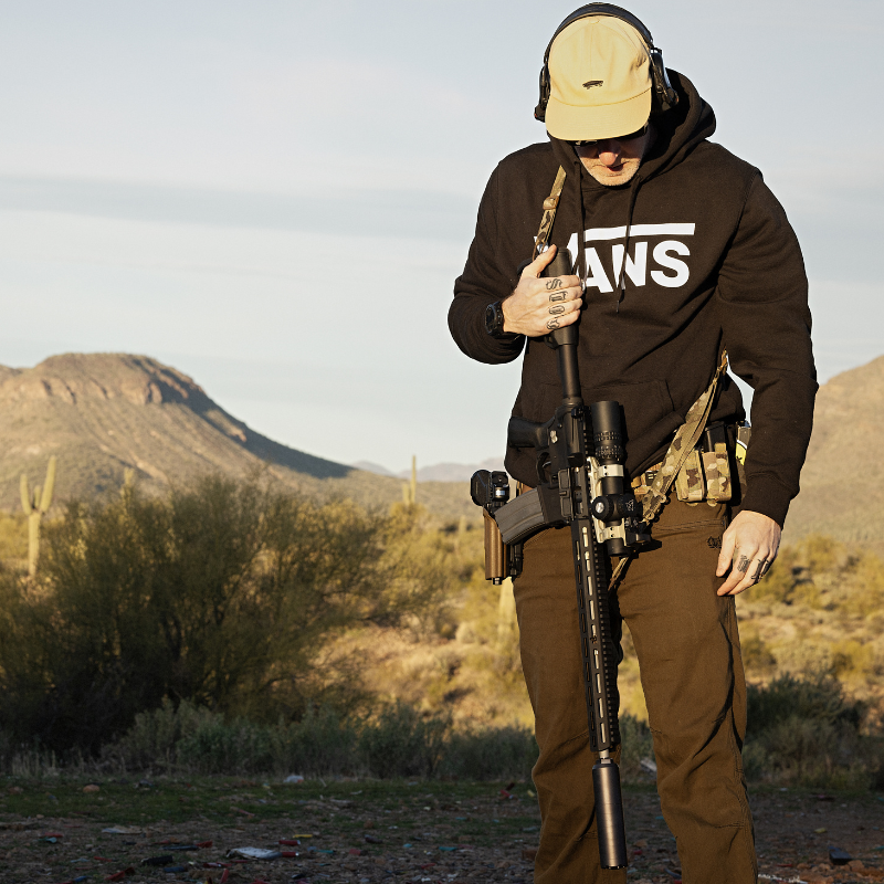 Lifestyle shot of the Carlos Ray Tactical Pants being worn at the range, highlighting the 4 way stretch mobility, dual mag pockets, reinforced tactical pocketing, and durable EDC ready design ideal for the best tactical pants, concealed carry use, shooting range training, and outdoor performance.