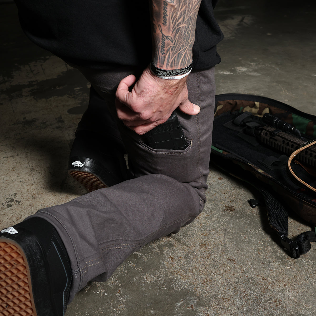 Lifestyle photo showing the Carlos Ray V3 Tactical Pants with the side mag pocket in active use, demonstrating secure magazine retention and fast-access tactical carry functionality during real-world movement.