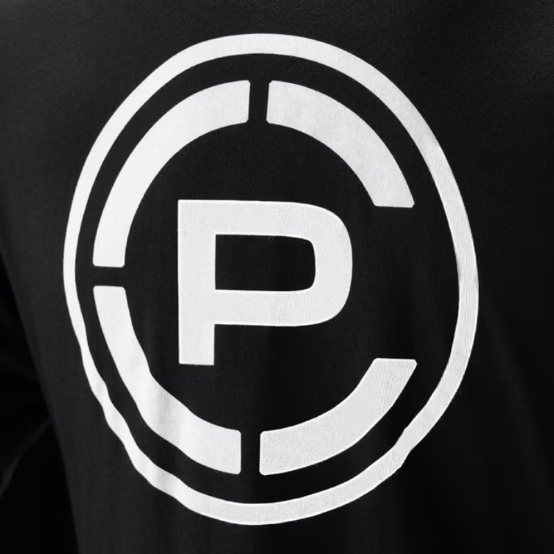 Close-up of a black garment featuring a large white circular logo with a stylized letter CP in the center.