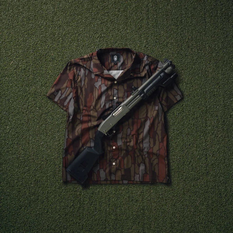 Treebark Camouflage-patterned shirt with a shotgun on a green textured background