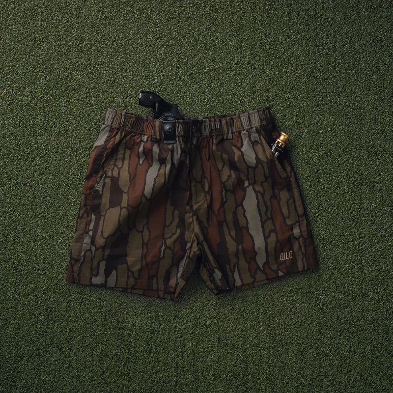 Trebark Camouflage-patterned shorts on a green textured background