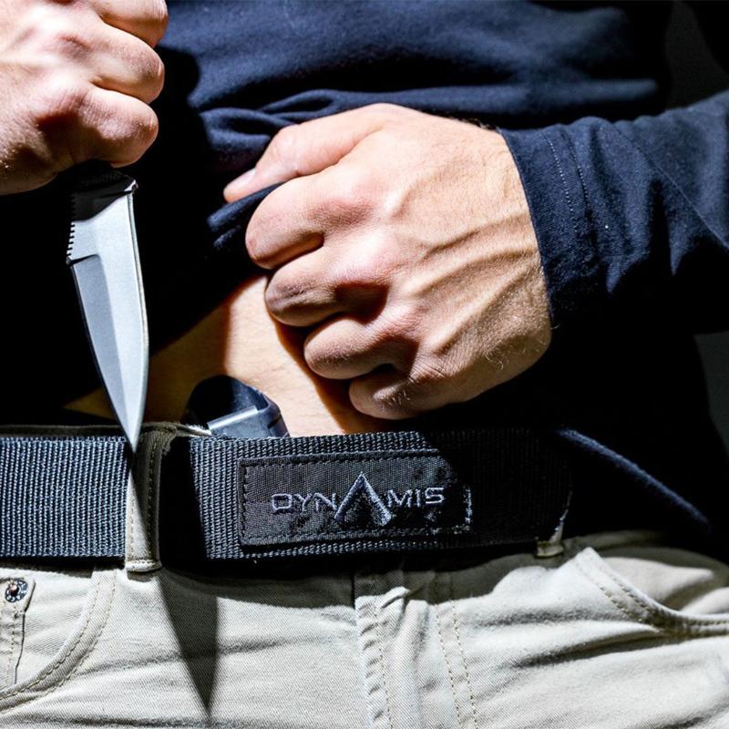 User accessing a concealed storage compartment built into the Dynamis Alliance 1.75 Inch LOPRO Belt for discreet everyday carry organization.