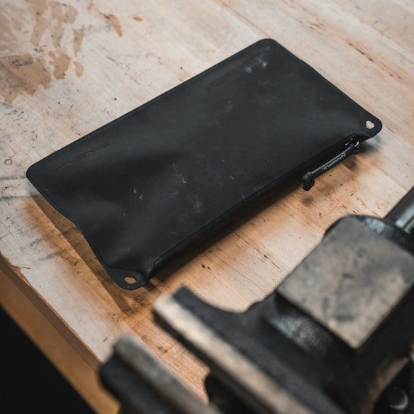 Magpul DAKA Pouch Medium waterproof gear organizer packed with tools and everyday carry items on workbench showing durable polymer construction and organized storage solution