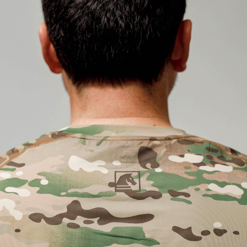 Close-up of the back of the MultiCam tactical range shooter shirt showing TD branding and durable flat-lock seam construction