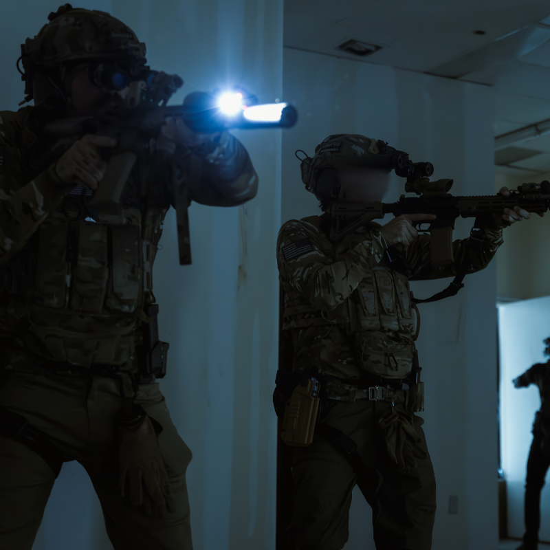 Operators wearing MultiCam tactical shooter shirts as base layers during combat missions, demonstrating moisture-wicking performance and mission-ready durability.