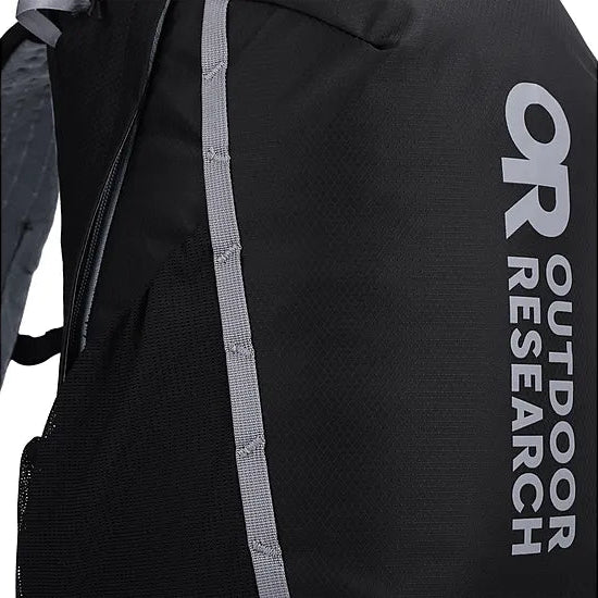Detail view of the Outdoor Research Adrenaline Day Pack 30L in black, showing multiple zipper locations including padded top pocket, hydration sleeve access, and hip belt storage for organized alpine carry.