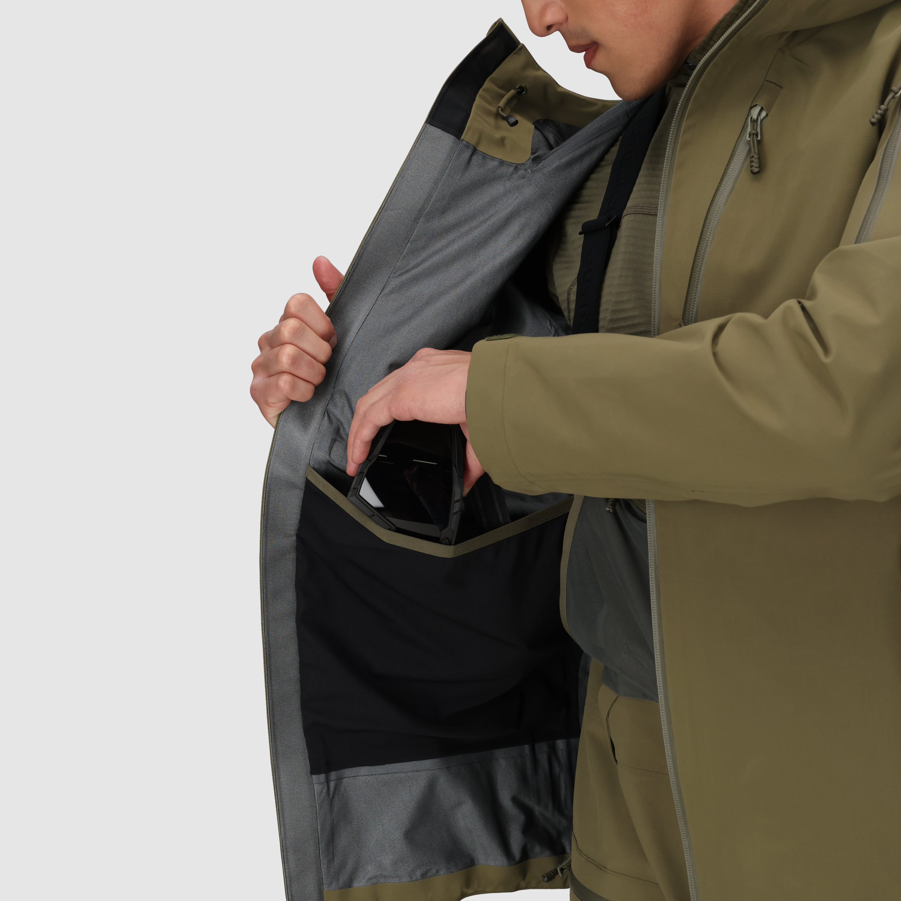 Close up of the Outdoor Research Allies Mountain II Jacket in Ranger Green showing the internal mesh and chest pockets in use, highlighting the organized storage layout, AscentShell waterproof protection, and Cordura ripstop durability designed for military, law enforcement, and alpine professionals needing mission essential gear access.