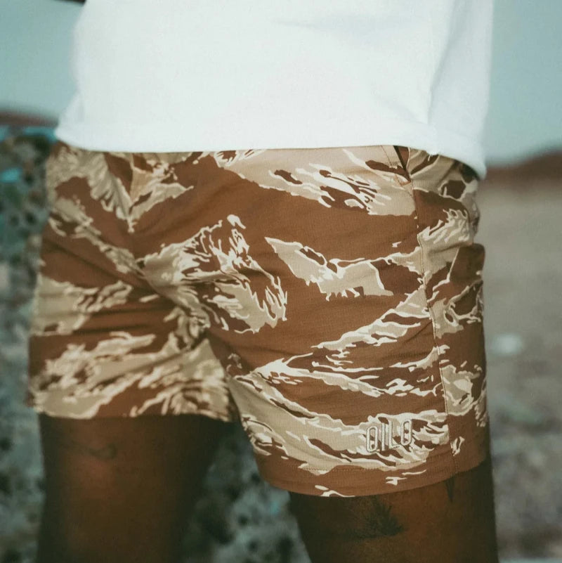 Person wearing tiger stripe camouflage shorts with a blurred background