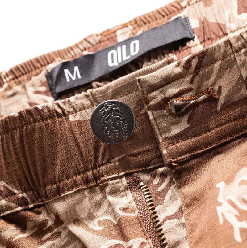 Desert Tiger Stripe Camouflage pants with a QILO x WRMFZY brand label on a white background
