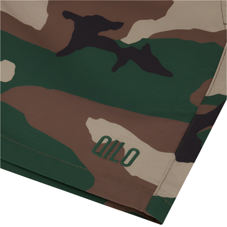 Detail view of QILO x WRMFZY collaboration shorts showcasing custom logo button and tactical upgrades