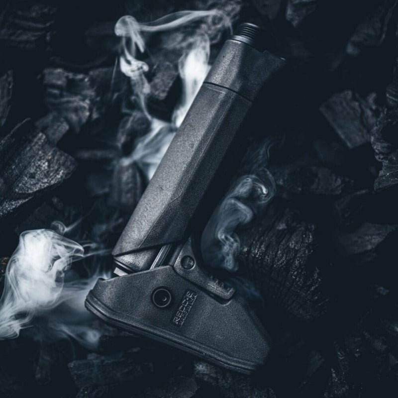 Reptilia RECC-E Stock in Black displayed beside glowing coals, symbolizing rugged performance and heat-tested reliability. Lightweight 12 oz AR-15/M4 carbine stock engineered for precision shooters and tactical operators. Features constant cheek weld, ambidextrous QD sling points, and modular compatibility for A5/SR25 buffer systems. Built for real-world missions, not just the range. Made in the USA.