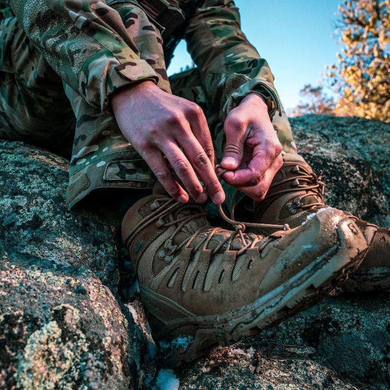 Close-up of Salomon Quest 4D Forces 2 Boots during field preparation, emphasizing durability and tactical functionality.
