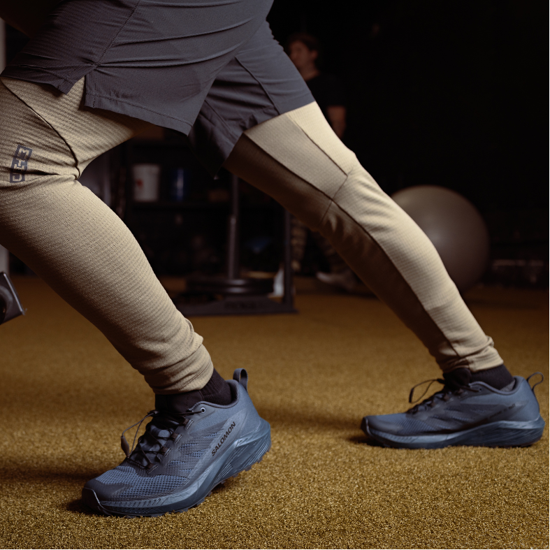 Lifestyle photo of the Salomon Trail Running Shoe in Black being worn during indoor gym training, showing the supportive midsole and slip-resistant outsole in action. Designed for tactical athletes, law enforcement, and EMS professionals who train hard and move fast. Combines lightweight comfort, durability, and grip for high-intensity workouts, rucking, and conditioning sessions.