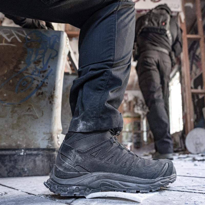 Salomon XA FORCES MID Black tactical boots shown worn in a tactical law enforcement environment | Lightweight all terrain combat footwear with Quicklace system reinforced chassis and durable outsole built for police military and special operations use