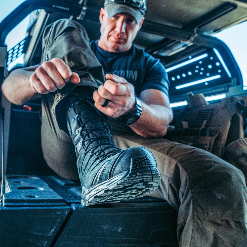 Operator wearing Salomon XA Forces 8 Inch GTX boots while preparing equipment, demonstrating comfort and support during extended operational use.