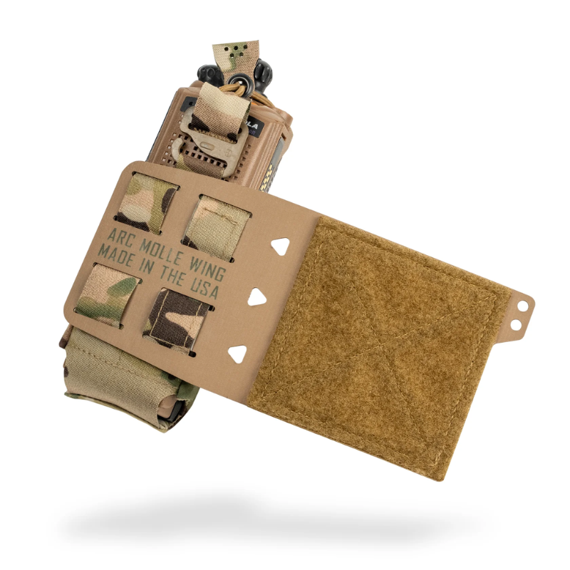 A tan tactical radio mounting wing with a Velcro-style flap and a mounted radio, shown on a clean white background with a soft shadow underneath.
