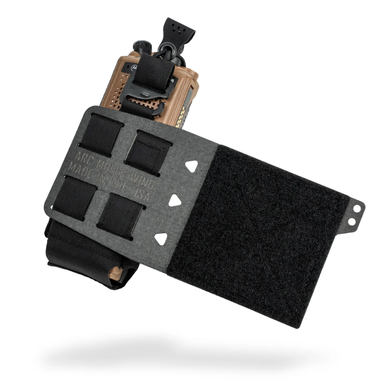 A tactical radio wing attachment with a black Velcro panel, black straps, and a tan/black radio mount, shown floating against a white background.