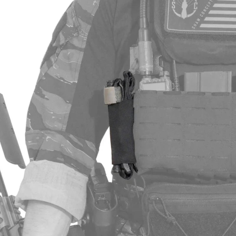 Close up of Shaw Concepts Elastic TQ Add On Pouch mounted on plate carrier, low profile MOLLE tourniquet holder with elastic retention and Tegris tuck tab integrated into combat gear, military loadouts, and law enforcement duty medical setups made in the USA