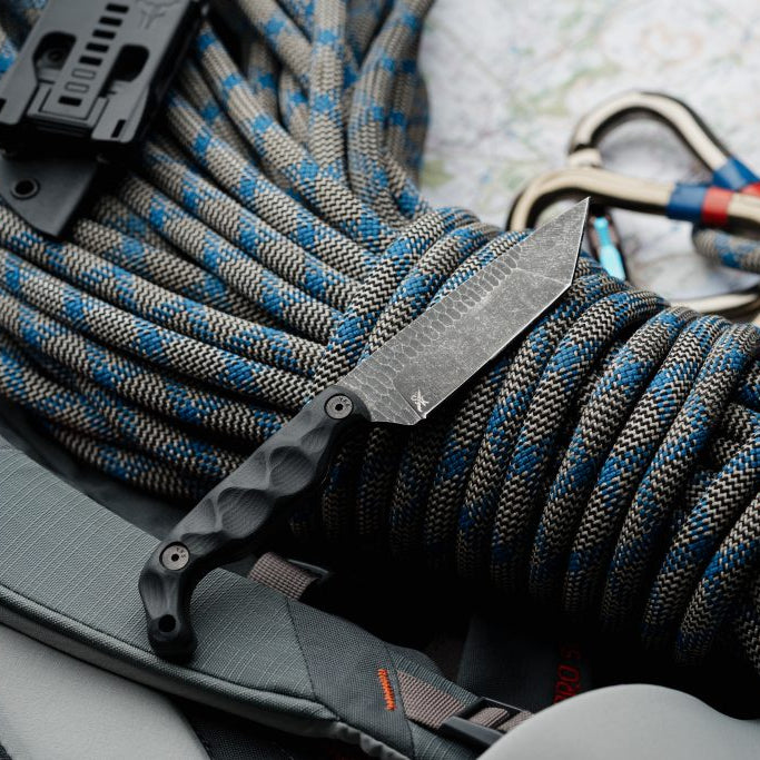 Flat lay of the Stroup Knives Bravo 5 Tanto fixed blade, highlighting its full-tang 1095 high-carbon steel construction, tanto point strength, and versatile Kydex sheath built for field use and everyday carry.