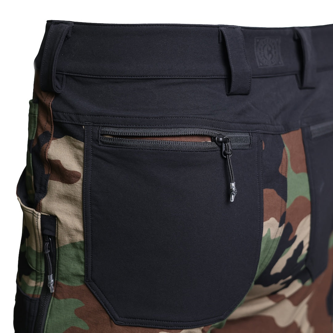 Close-up of the TD Cordell Combat Pants V2 in the Colorblocked M81 Woodland and Black version showing the rear zippered pockets with durable YKK zippers. Highlights secure EDC storage, reinforced stitching, and the rugged softshell construction designed for field durability. Ideal for users searching for tactical pants with secure back pockets, M81 Woodland combat pants with zipper storage, and colorblocked EDC trousers built for range use and daily carry.