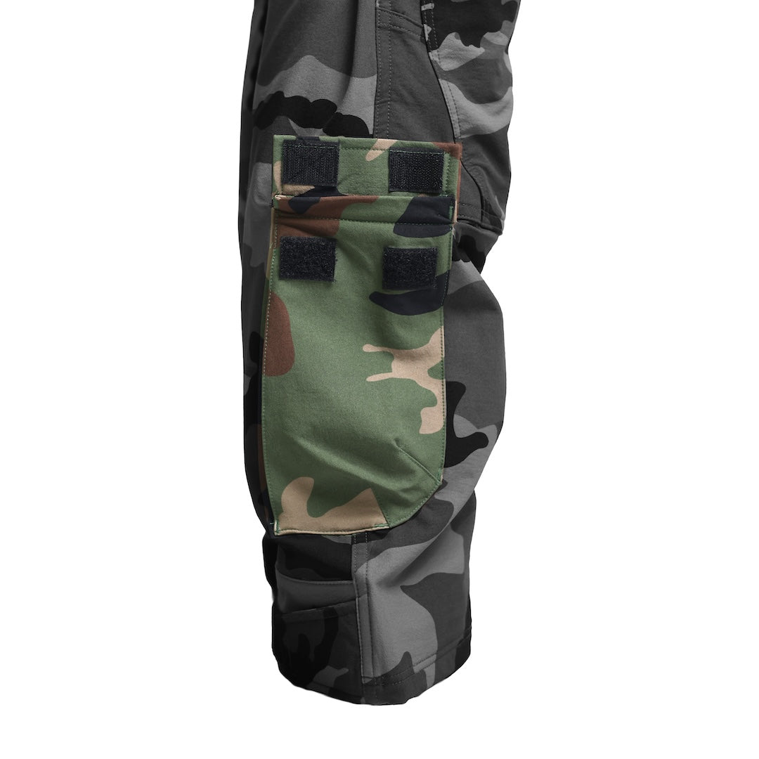 Close-up of the TD Cordell Combat Pants V2 in M81 Woodland showing the new ankle pocket designed to securely hold a tourniquet or compact first-aid essential. Highlights the easy-access placement, reinforced construction, and mission-driven pocket layout ideal for EDC, range training, and tactical field use. Perfect for users searching for combat pants with medical storage, tourniquet-ready pockets, and advanced functional design.