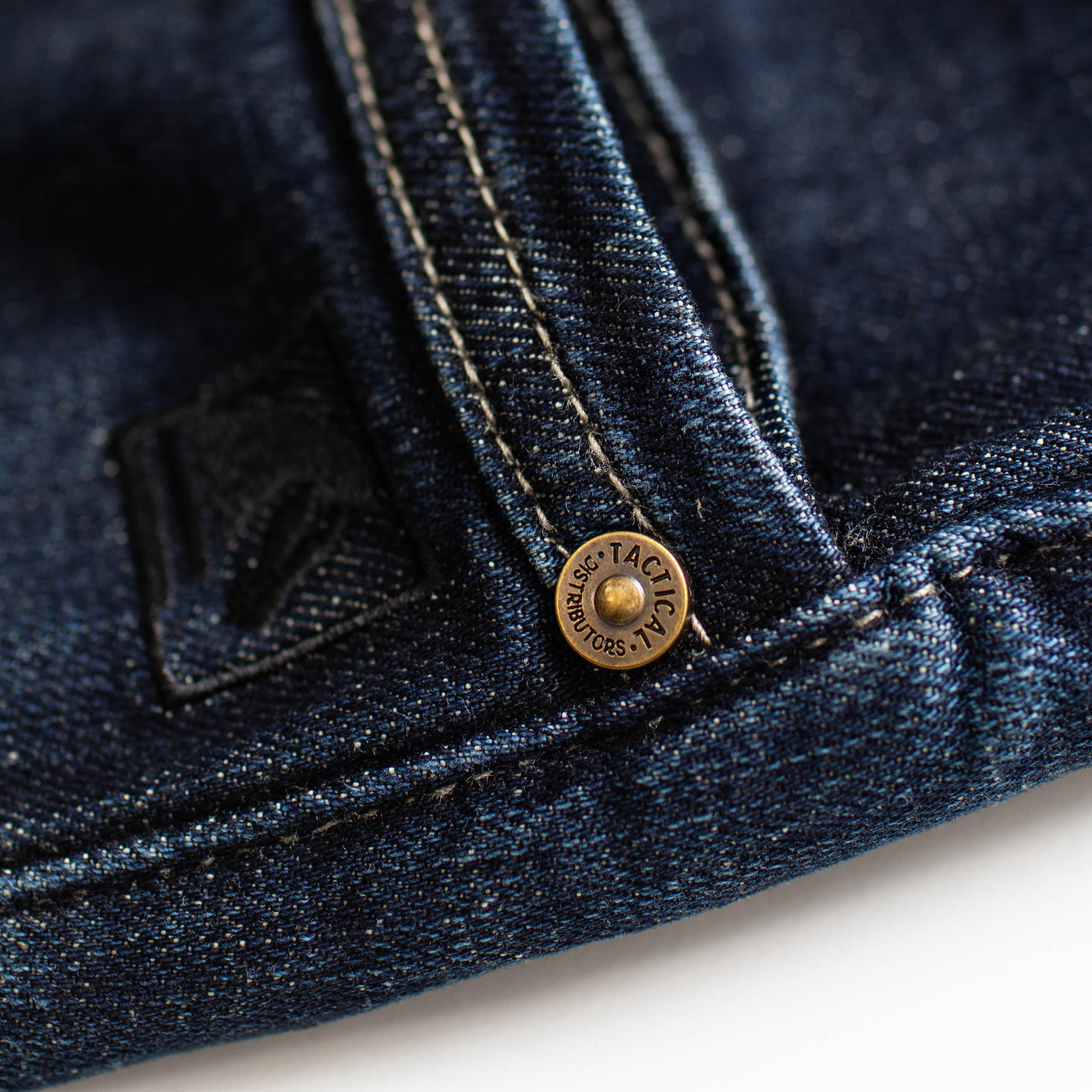 Close up of the TD McQuade Tactical Jeans showing the branded rivets and reinforced stitching designed for durability, concealed carry support, and everyday EDC tactical performance.