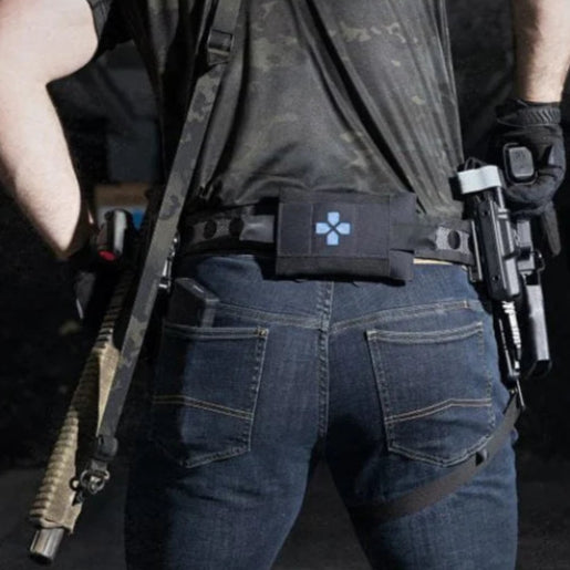 Back view of TD McQuade EDC Tactical Jeans worn at the shooting range with tactical belt and leg straps, showcasing reinforced rear pockets, stretch denim fit, and secure concealed carry setup for tactical and EDC use