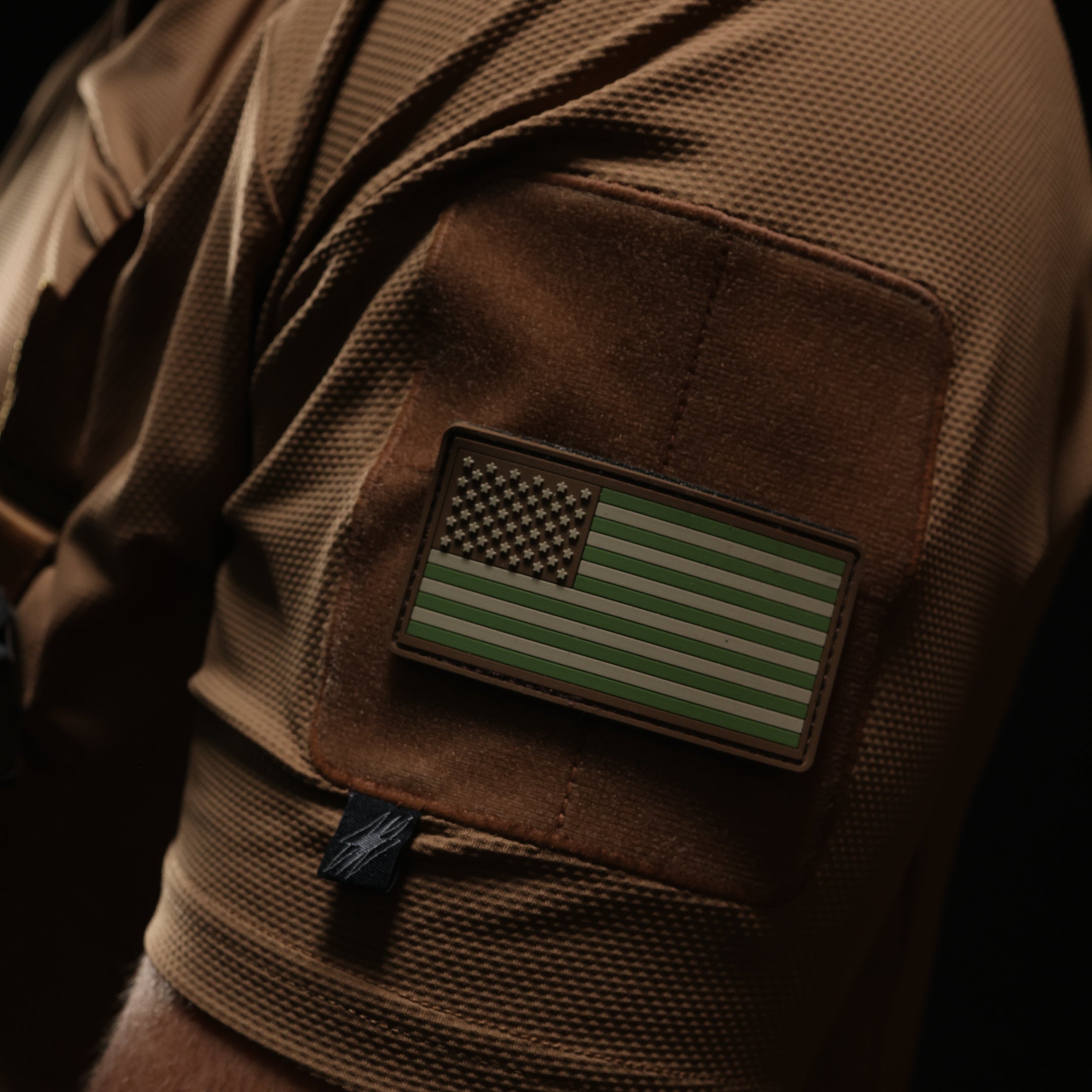 Close up of TD OSS Top Short Sleeve in Coyote showing low profile bicep loop patch field and clean sleeve construction, lightweight tactical range shirt and combat base layer designed for hot weather operator training and duty wear under plate carriers
